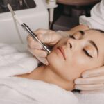 brunette-caucasian-woman-having-spa-procedure-skin-her-face-done-with-apparatus-by-spa-worker_129180-852