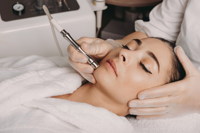 brunette-caucasian-woman-having-spa-procedure-skin-her-face-done-with-apparatus-by-spa-worker_129180-852